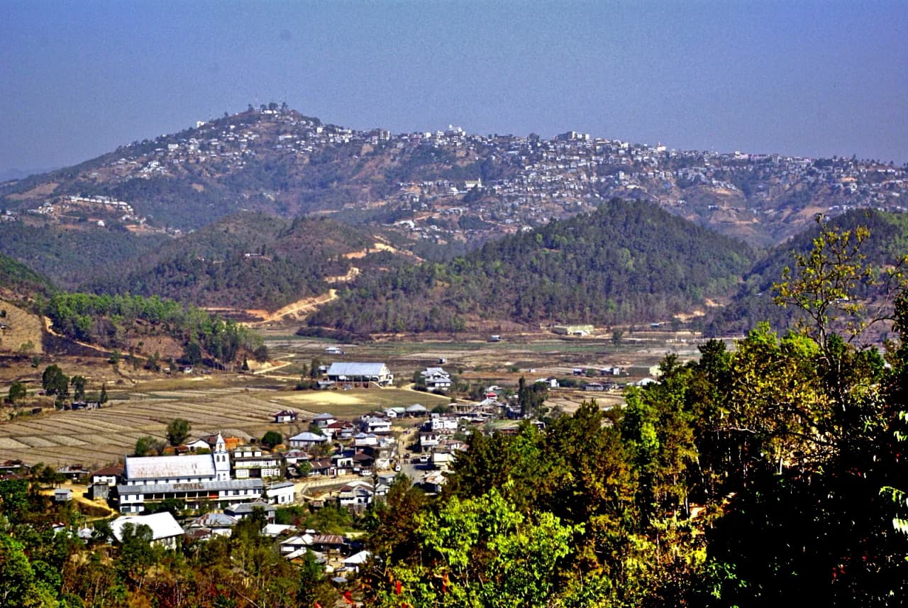 Champhai, Mizoram, from south, with Zotlang in the foreground. Taken from Ruantlang, across the Champhai Valley, with the town of Champhai stretched along the hill in the distance and the village of…